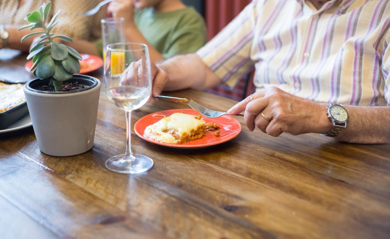 An intimate family meal with homemade lasagna served on a colorful plate, creating a cozy atmosphere.