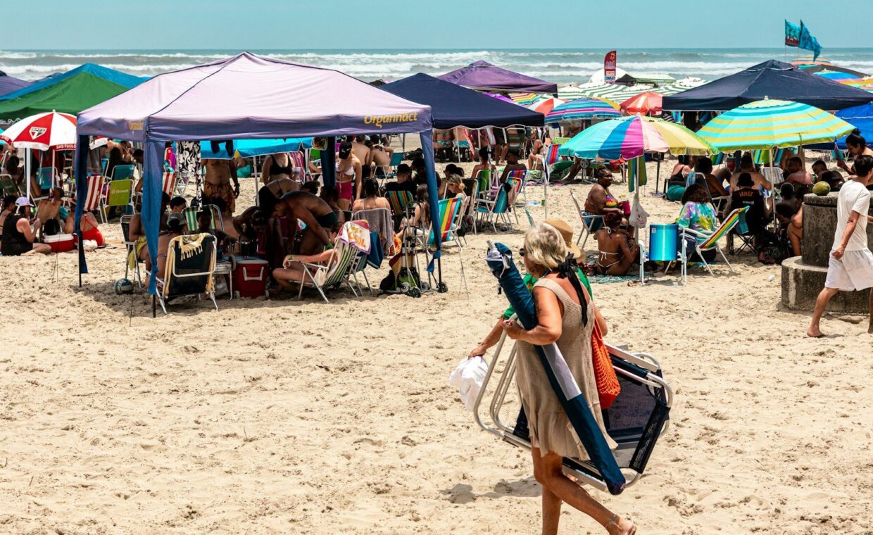 People relaxing under colorful umbrellas on a sunny beach.