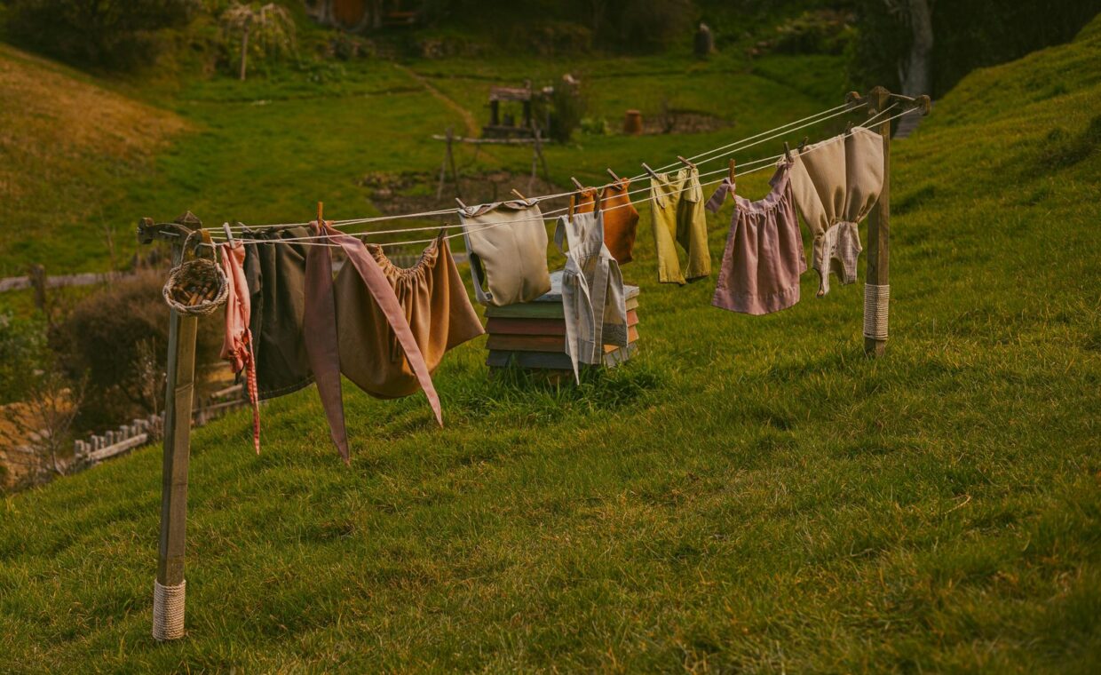 Colorful clothes hang on a rustic clothesline in a peaceful countryside environment.