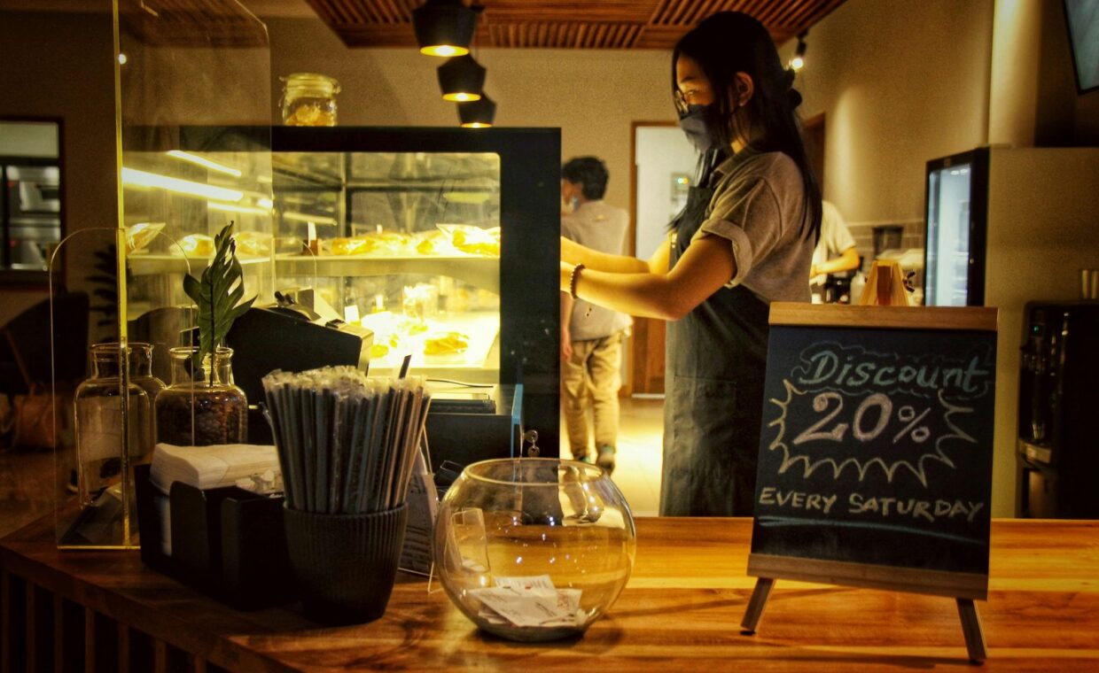 A cafe scene with a barista and discount chalkboard, creating a welcoming atmosphere.