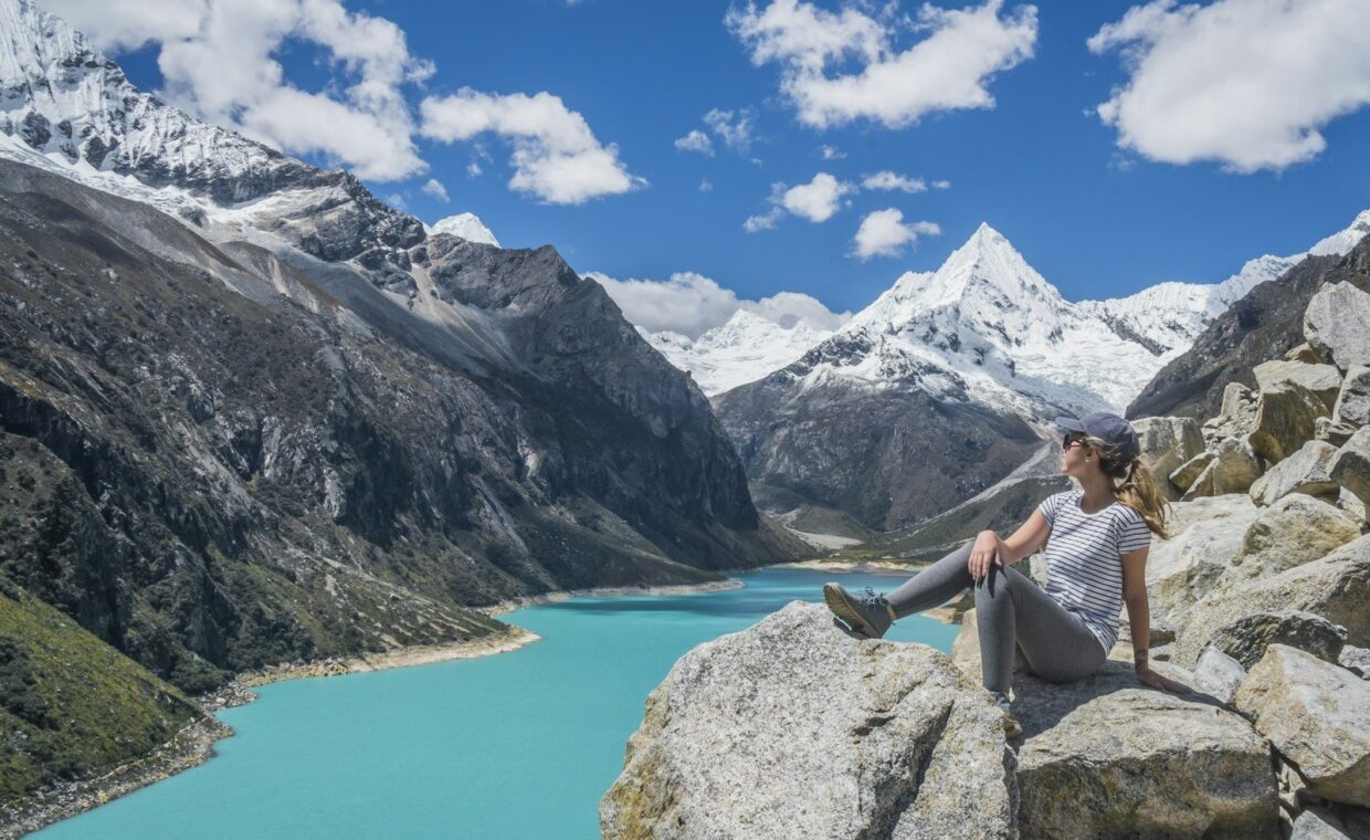 girl sitting on rock near body of water at daytime