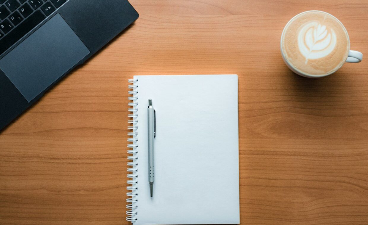 a pen and a cup of coffee on a table