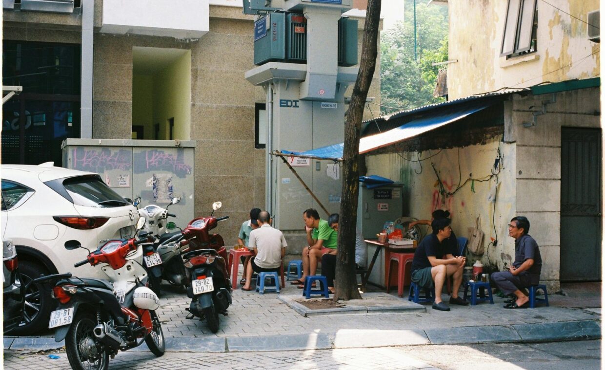 A casual gathering of locals on a Hanoi street, capturing urban Vietnamese life.