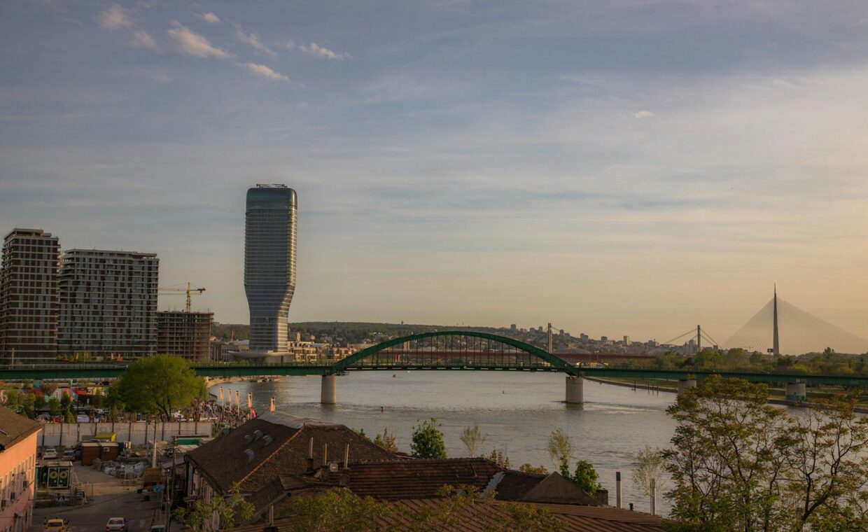 a bridge over a river with a city in the background