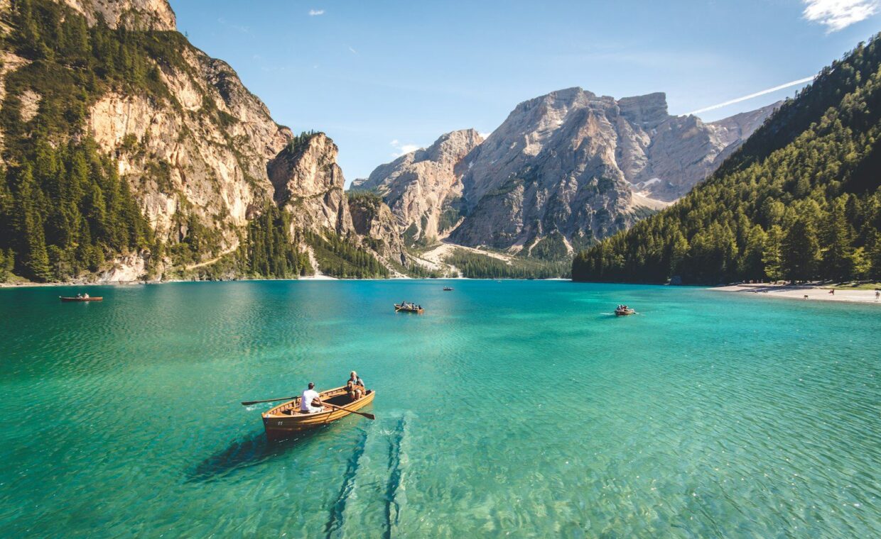 three brown wooden boat on blue lake water taken at daytime